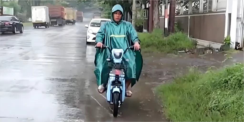 Gambar mengendarai sepeda listrik saat hujan